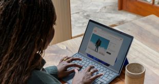 a woman sitting at a table using a laptop computer